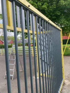 Portail métallique gris et jaune en extérieur